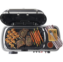Offener Grill mit Steaks, Garnelen, Karotten und Zubehör