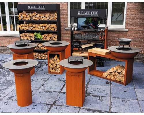 Ausstellung mit Feuerstellen, Grillzubehör und Brennholzregalen der Marke Tiger Fire