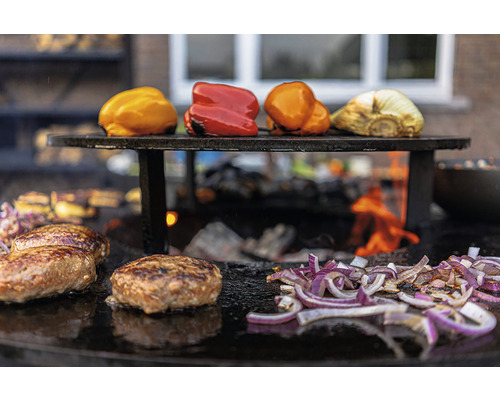 Légumes, oignons et hamburgers sur une plaque de cuisson