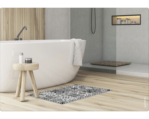 Salle de bains avec baignoire, tabouret et tapis de bain à motifs