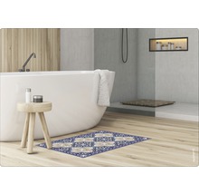 Scène de salle de bains avec baignoire, tabouret, articles de décoration et tapis de bain à motifs