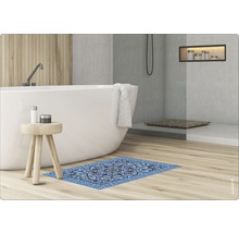 Salle de bains avec baignoire îlot, tabouret en bois et carreau de moquette bleu à motif ornemental