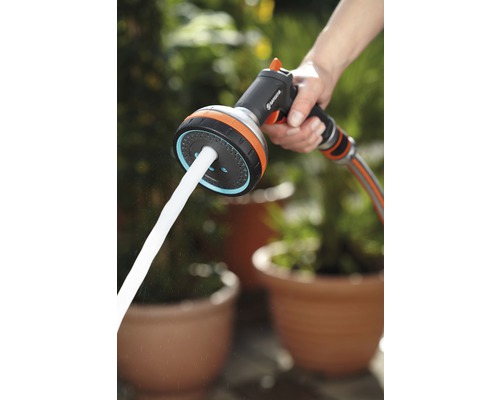 Pistolet d''arrosage pour tuyau d''arrosage avec jet d''eau dans la main.