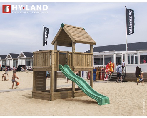 Tour de jeux avec toboggan sur une plage de sable avec des personnes et des cabanes de plage