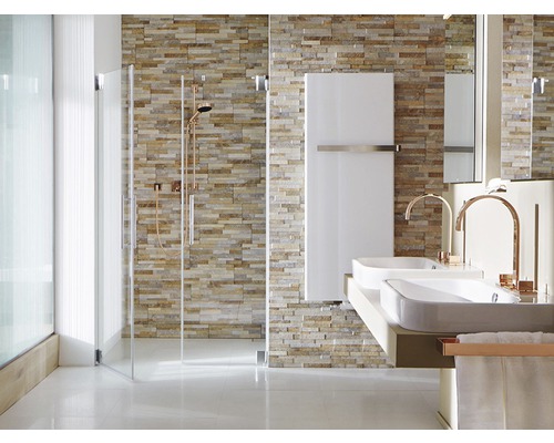 Salle de bains avec douche, lavabos et radiateur devant un mur en pierre