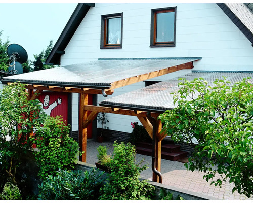 Überdachte Terrasse mit Holzkonstruktion und transparentem Dach am Haus.