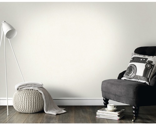 Pièce lumineuse avec fauteuil, lampe et peinture murale