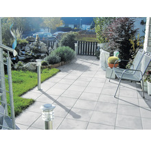 Terrasse avec jardin, équipée de mobilier de jardin, de dalles de sol et de luminaires extérieurs.