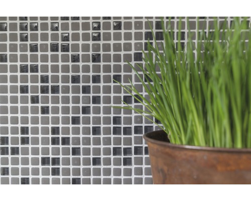 Mur de carreaux de mosaïque avec plante en pot au premier plan
