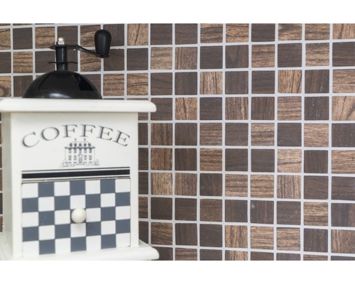 Moulin à café décoratif devant un fond en mosaïque