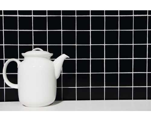 Théière en céramique devant un motif de carreaux carrés