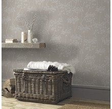 Pièce confortable avec papier peint à motifs floraux, panier en osier et parquet