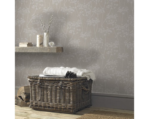 Pièce confortable avec papier peint à motifs floraux, panier en osier et parquet