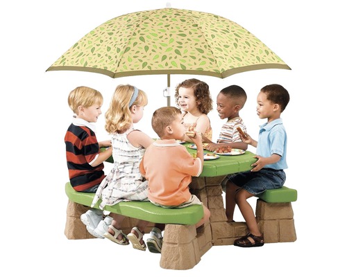 Des enfants sont assis à une table de pique-nique avec un parasol