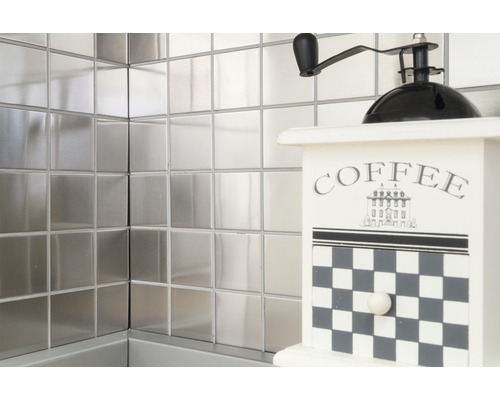 Carreaux métalliques carrés sur le mur avec un moulin à café décoratif