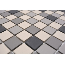 Mosaikfliesen mit quadratischen Elementen in verschiedenen Grautönen.