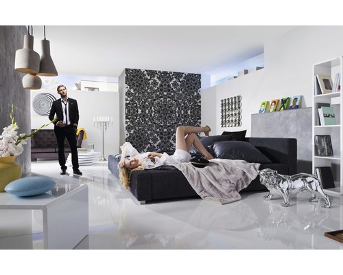 Salon lumineux avec canapé, lit, décoration et deux personnes