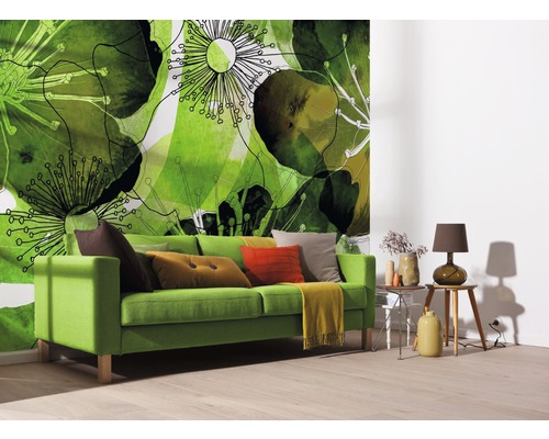 Salon avec canapé vert, coussins et papier peint photo avec motifs végétaux