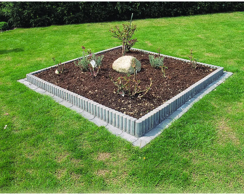 Parterre carré avec plantes et bordures à rouleaux dans le jardin