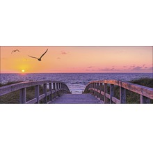 Holzbrücke am Strand mit Blick auf das Meer und den Sonnenuntergang