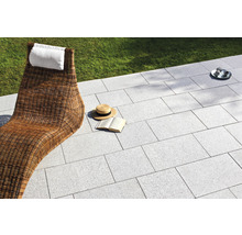 Terrasse mit Steinplatten, Liegestuhl und Accessoires