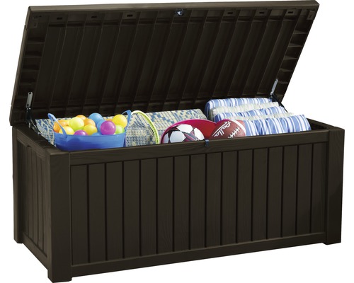 Geöffnete, braune Aufbewahrungsbox für den Aussenbereich, gefüllt mit Spielzeug und Kissen