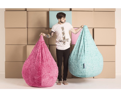 Mann hält zwei tropfenförmige Sitzsäcke aus Stoff