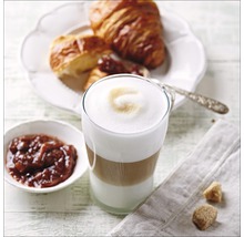 Latte macchiato dans un verre avec croissant et confiture