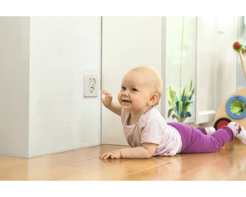 Bébé rampant vers la sécurité de prise de courant à l''intérieur