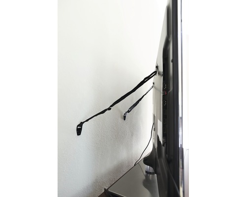 Téléviseur fixé au mur avec des sangles de fixation