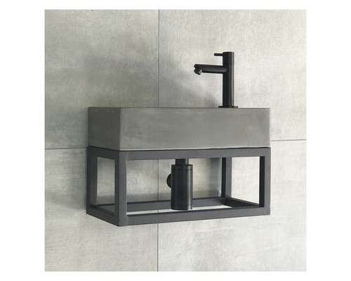 Waschtisch mit Betonbecken und Metallgestell an der Wand