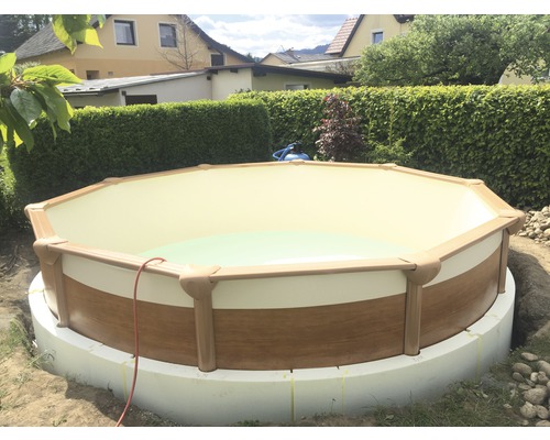 Piscine hors-sol dans le jardin avec revêtement en bois et bord de piscine