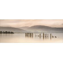 Landschaft mit See, Bergen und alten Holzpfosten