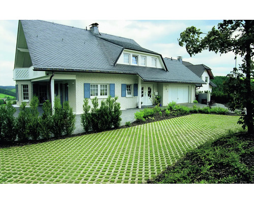 Maison individuelle avec une surface de grille engazonnée devant la maison