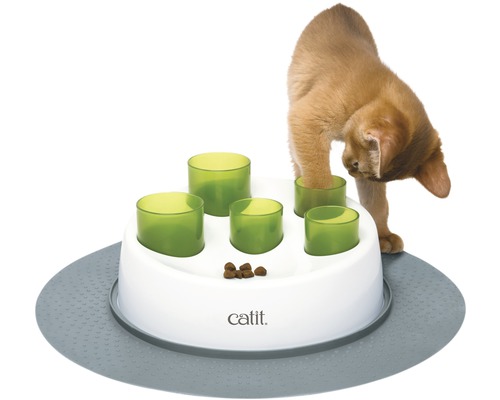 Chat jouant avec un jouet distributeur interactif Catit sur un tapis.