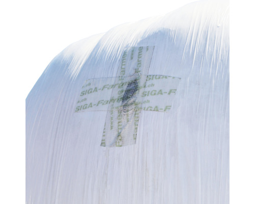 Vue détaillée d''une bâche d''ensilage blanche scellée avec un patch de réparation de la marque Siga