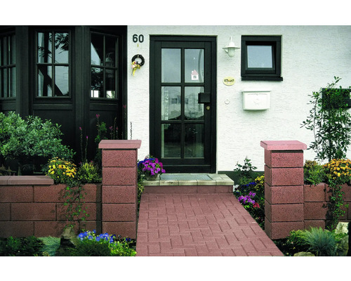 Eingangsbereich eines Hauses mit Pflastersteinen, Pflanzkästen und Eingangstür