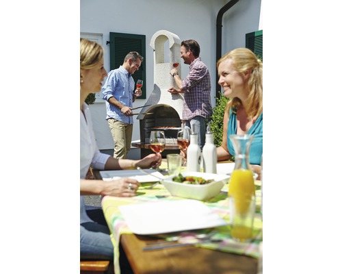 Gruppe von Personen beim Grillen im Garten mit einem gemauerten Grill und Gartentisch