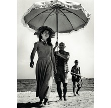 Photo en noir et blanc d''une femme marchant sur la plage avec un homme tenant un parasol et un homme tenant une lance