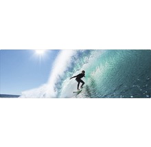 Surfeur montant une vague sur une planche de surf