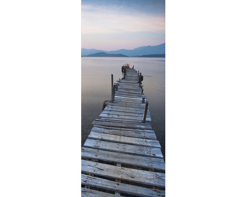 Holzsteg führt ins Wasser mit Bergkulisse im Hintergrund