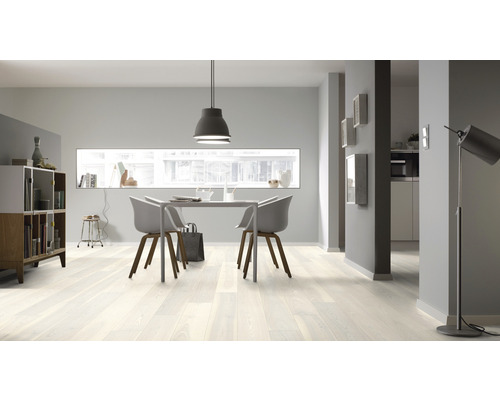 Salon lumineux avec plancher en bois, table à manger et chaises.