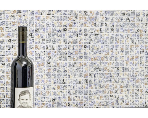 Mosaïque à motif floral en arrière-plan et une bouteille de vin au premier plan