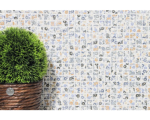 Mosaïque décorative à motif floral et plante artificielle en pot.