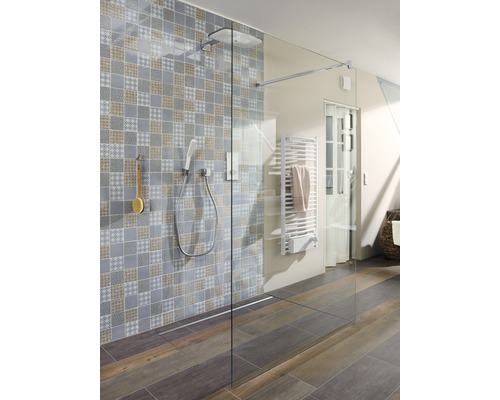 Salle de bains avec douche à l''italienne avec pomme de douche, douchette, caniveau de douche, sèche-serviettes chauffant et mur à motifs