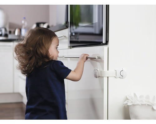 Un enfant essaie d''ouvrir un tiroir sécurisé par un dispositif de sécurité enfant