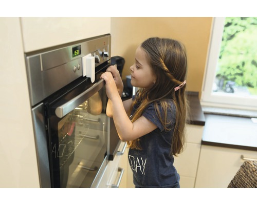 Kind mit Herdsicherung an einem Backofen