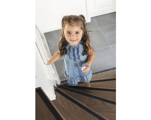 Fille dans les escaliers avec des bandes antidérapantes