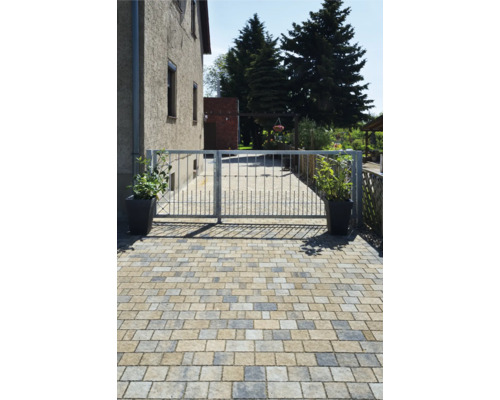 Allée avec pavés et portail métallique devant une maison