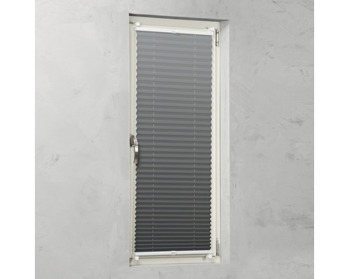 Store plissé gris sur une fenêtre pour le contrôle de la lumière